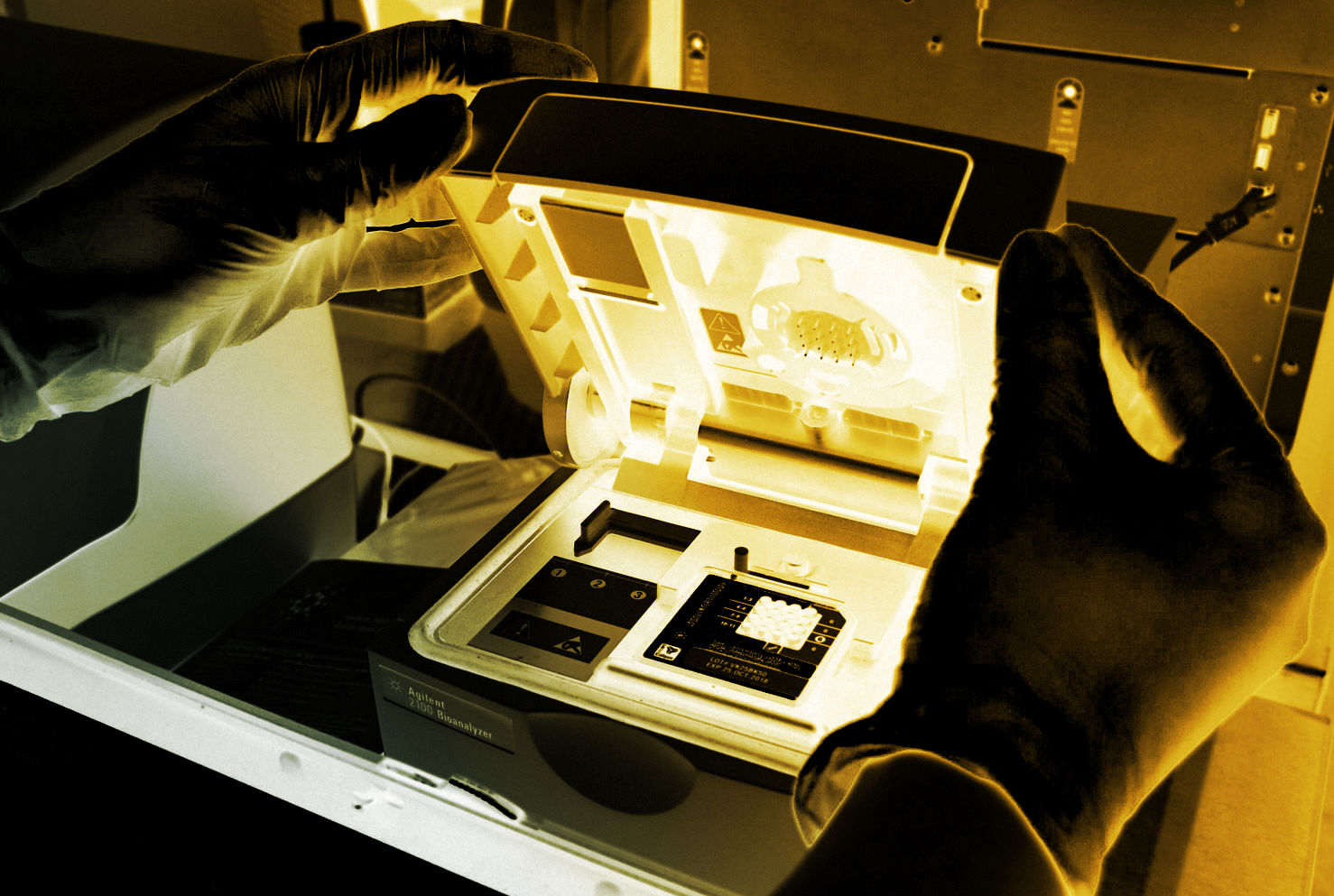 Gloved hands opening an Agilent 2000 Bioanalyzer